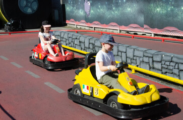 A child drives a Go-kart car in the racing arena of the playground