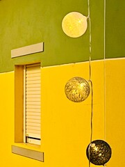 Decorative hanging balls in front of bright building and window