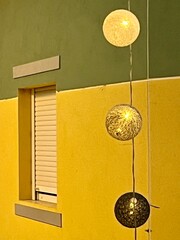 Decorative hanging balls in front of bright building and window