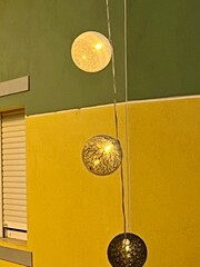 Decorative hanging balls in front of bright building and window