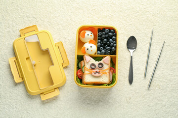 Lunch box with snacks, spoon and chopsticks on beige textured table, flat lay