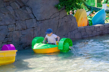Kid playing rowing water paddle boat. Soft focus.