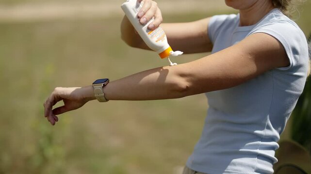 Woman applying sunscreen sun protection outdoors on sunny day