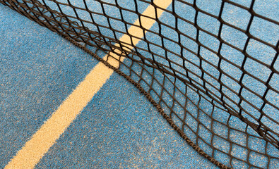 white line on a blue paddle tennis court.