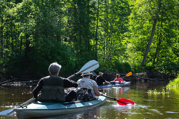 Group kayak trip for seigneur and senora . An elderly couple And adult rowing boat on the river, a water hike, a summer adventure. Age-related sports, mental youth and health, tourism, active old age