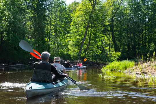 Group kayak trip for seigneur and senora . An elderly couple And adult rowing boat on the river, a water hike, a summer adventure. Age-related sports, mental youth and health, tourism, active old age