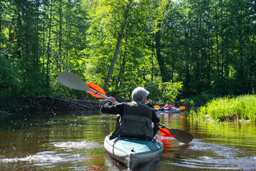 Group kayak trip for seigneur and senora . An elderly couple And adult rowing boat on the river, a...