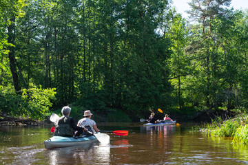 Group kayak trip for seigneur and senora . An elderly couple And adult rowing boat on the river, a water hike, a summer adventure. Age-related sports, mental youth and health, tourism, active old age