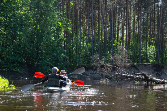 Group kayak trip for seigneur and senora . An elderly couple And adult rowing boat on the river, a water hike, a summer adventure. Age-related sports, mental youth and health, tourism, active old age