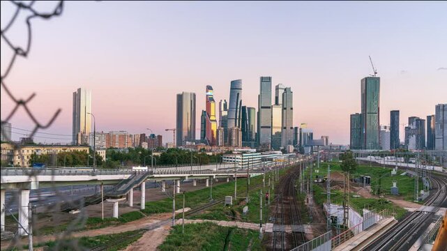 Time-Lapse of Moscow City Skyline Viewed Through Torn Fence at Sunset