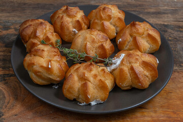 Homemade profiteroles on ceramic plate.