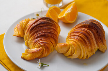 Brioche croissants on a plate with oranges