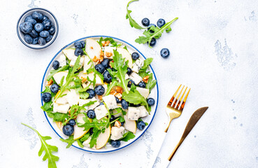 Gourmet salad with pears, blueberries, gorgonzola cheese, arugula and walnuts. White background,...