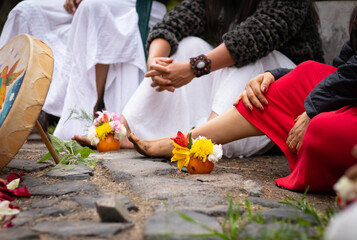 bouquet of flowers at the foot of a circle of barefoot women