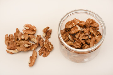 Walnuts in a plastic jar on a white background.