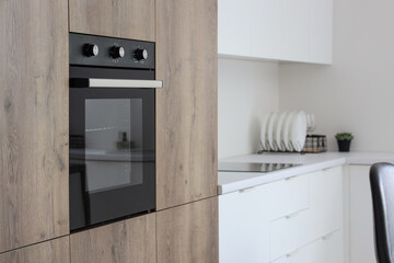 Wooden furniture with modern built-in oven in kitchen