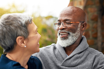 Interracial senior couple, smile and care in park, garden or nature for hug or love together. Happy...