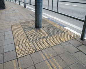 Tactile zone on the sidewalk around the lamp post