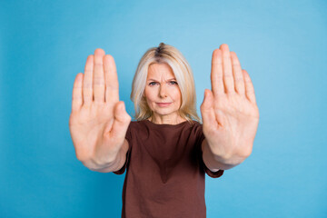 Photo of serious retired lovely woman wear stylish brown clothes keep distance isolated on blue...