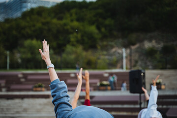 A lively group of people, full of energy and enthusiasm, are collectively raising their hands high...