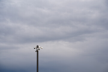 A strong and durable metal pole equipped with a highdefinition camera diligently captures the breathtaking beauty of the sky along with the picturesque landscape that surrounds it