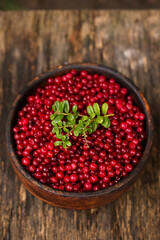 Full wooden bowl of ripe juicy lingonberries