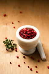 A stone mortar full of ripe wild lingonberries, on a wooden background
