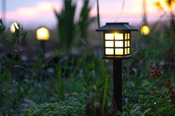 Solar-powered lanterns for flower beds in the yard of the house for decorative street lighting and landscaping © Ольга Симонова
