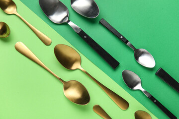 Different stylish spoons on color background