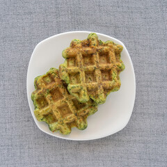 Green waffles on ceramic plate.