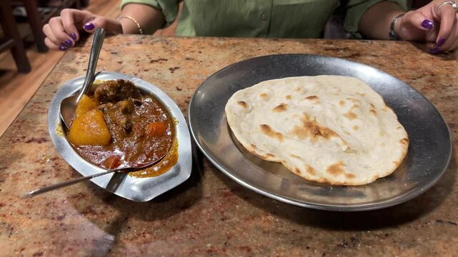 Mutton gravy with tandoori roti at a local restaurant in Kolkata, India.
