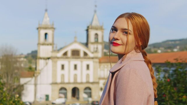 Stunning 4k footage of a young white caucasian ginger girl posing in front of the Abade Pedrosa Municipal Museum and the Monastery of St. Benedict (Sao Bento) in the Portugal city - Santo Tirso.