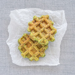 Green waffles on paper background.