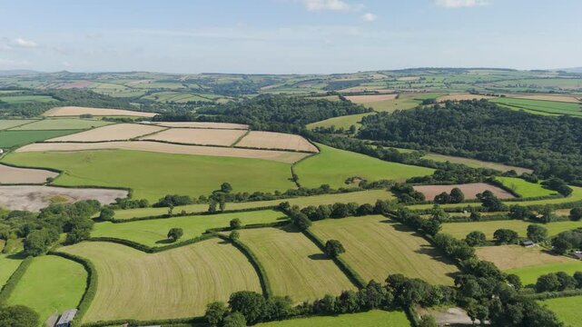 Aerial view of the picturesque Devonshire countryside, showcasing the rolling hills and lush green fields of Devon, England
