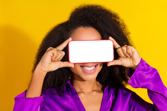 Photo portrait of pretty young girl headset white screen device cover eyes wear trendy violet outfit isolated on yellow color background - Powered by Adobe