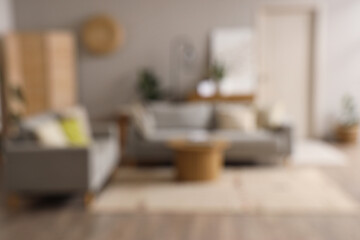 Blurred view of living room interior with grey sofas and coffee table