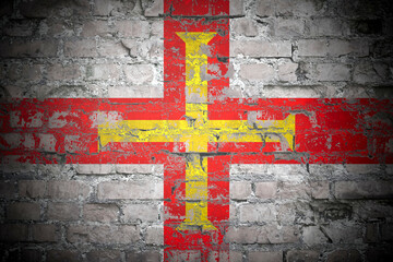 Flag of Guernsey on brick wall