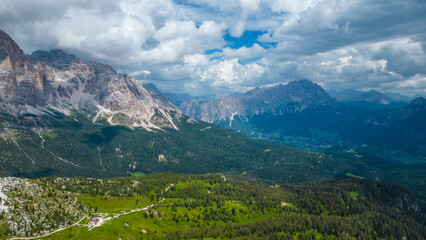 An aerial view of the incredible Cinque Torri mountains in the Dolomites, Italy, captured by a drone. This breathtaking shot showcases the dramatic rock formations and rugged beauty of  mountains