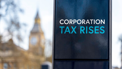 Corporation Tax Rises sign in front of Westminster	