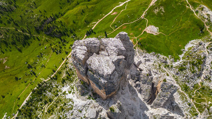 An aerial view of the incredible Cinque Torri mountains in the Dolomites, Italy, captured by a drone. This breathtaking shot showcases the dramatic rock formations and rugged beauty of  mountains