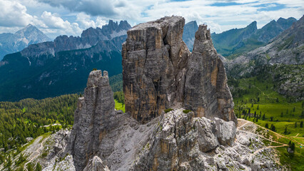 An aerial view of the incredible Cinque Torri mountains in the Dolomites, Italy, captured by a drone. This breathtaking shot showcases the dramatic rock formations and rugged beauty of  mountains