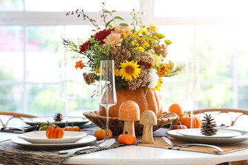 Pumpkin with autumn bouquet on dining table in kitchen, closeup