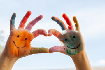 Children's painted hands with smiling faces. Happiness, joy, education, creative, school concept