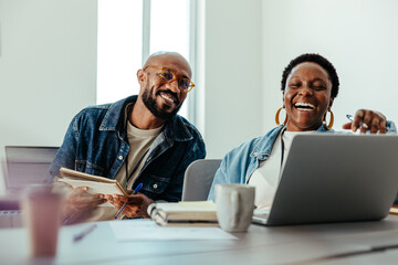 Happy employees laughing together during a casual business meeting