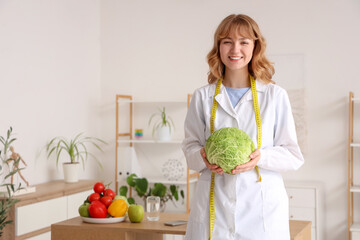 Female nutritionist with cabbage in office