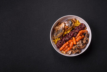 A colorful vegetarian dish consists of fish, beans, corn, mushrooms