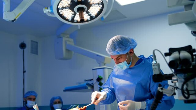 Uniformed male medic uses forceps and sponge to cover the bold head of a patient with iodine solution. Preparation for neurosurgery.