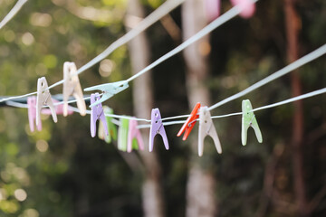 Laundry background. Clothespins on a clothesline. Drying clothes outdoors with clips. How to dry laundry in an open-air summer. Colorful plastic clothes clips texture.