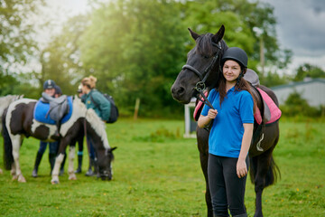 Obraz premium Girl, horse and development in nature for equestrian, portrait and learning with bonding or connection. Teenager, animal and pet outdoor for riding, care and fitness with smile, exercise and helmet