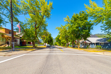 A wide tree lined street of homes in a residential neighborhood of the historic mining town of Kellogg, Idaho, in the Silver Valley district near Coeur d'Alene.